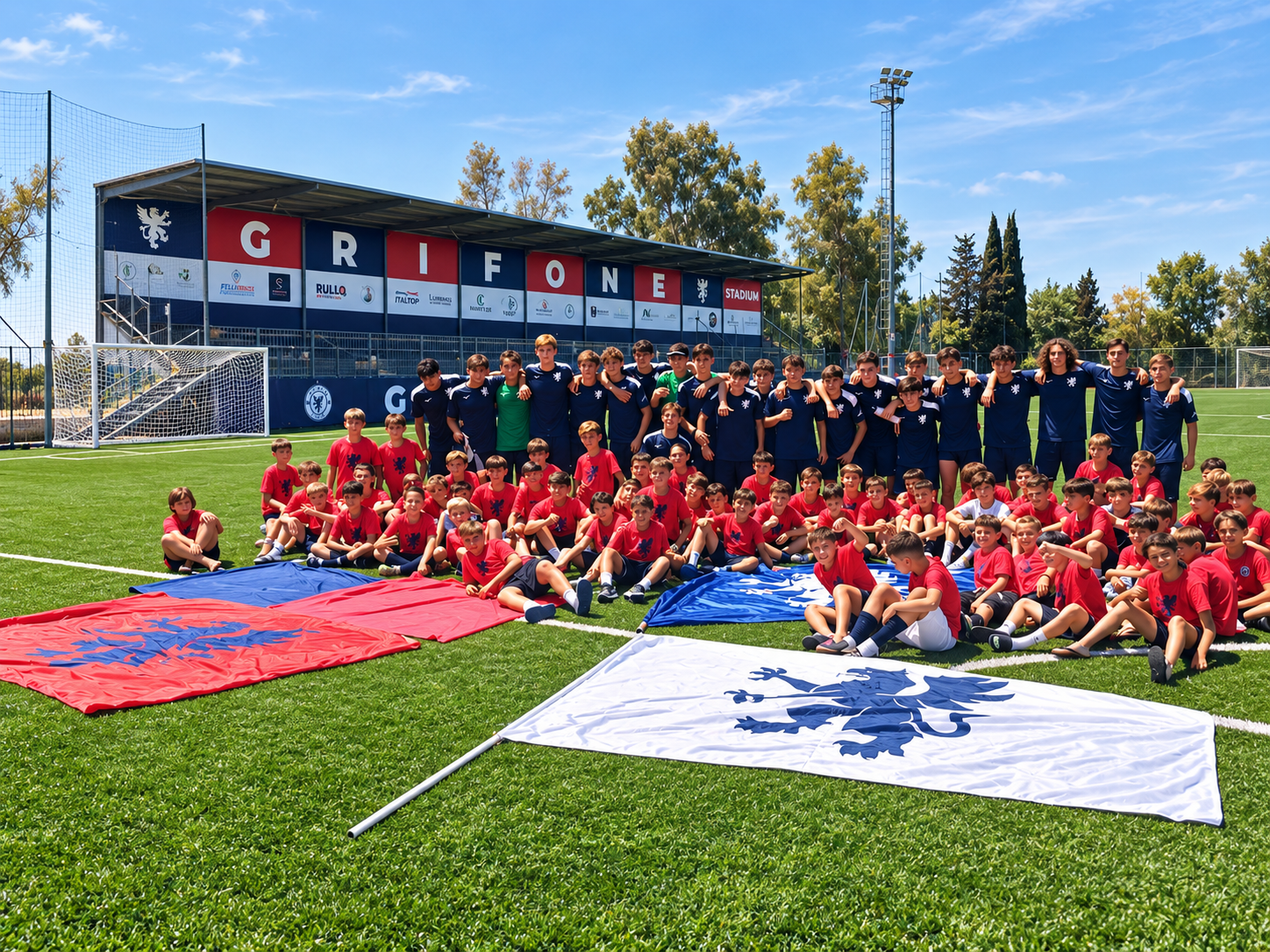 I ragazzi del Grifone Calcio schierati davanti al Grifone Stadium con le bandiere